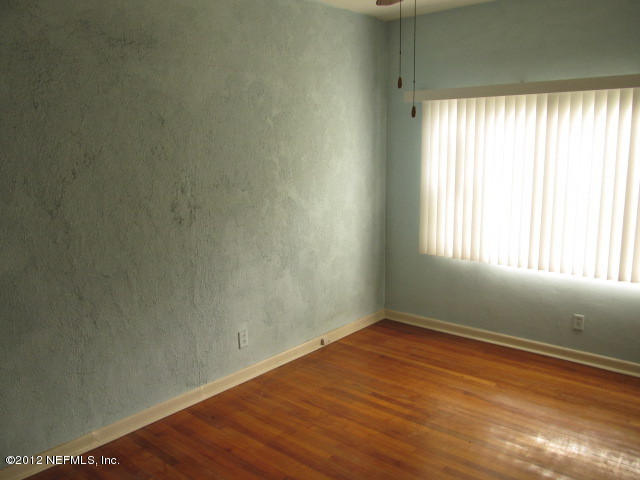 3245 Barkley Road Jacksonville, FL 32246 - Photo 3 of 11 an empty room with wooden floor and windows