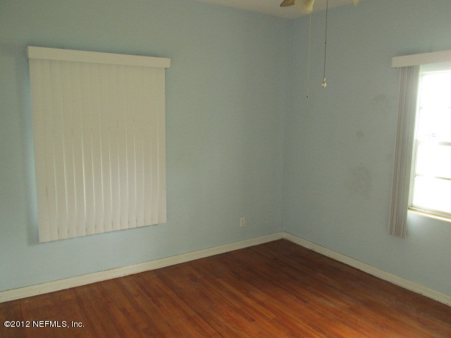 3245 Barkley Road Jacksonville, FL 32246 - Photo 7 of 11 an empty room with wooden floor and windows