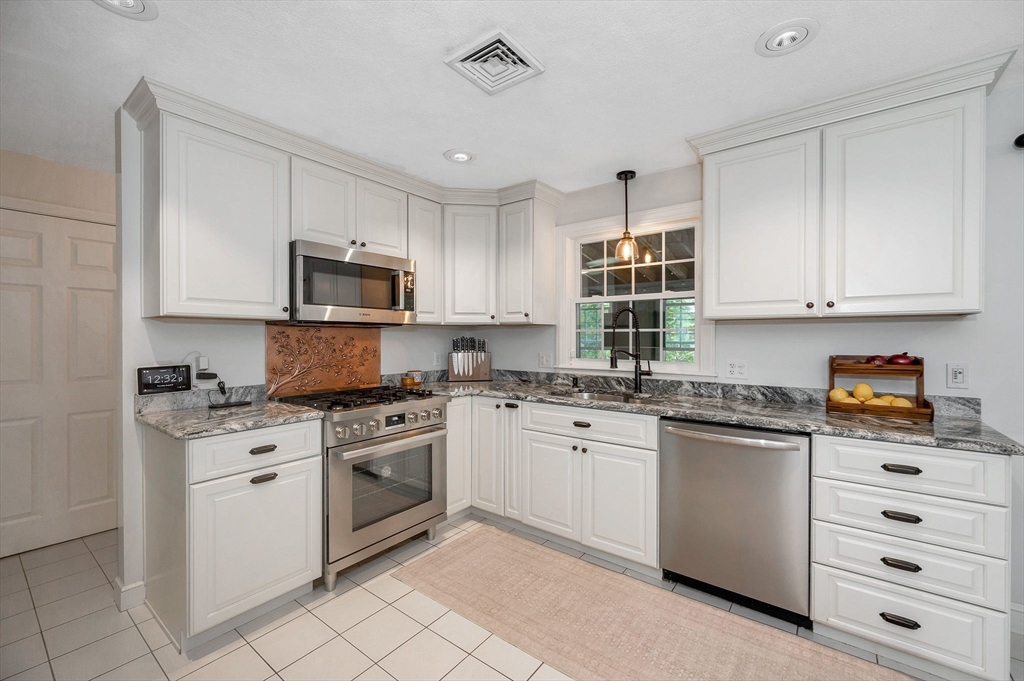 67 Reservation Road Andover, MA 01810 - Photo 12 of 40 a kitchen with granite countertop white cabinets and white appliances