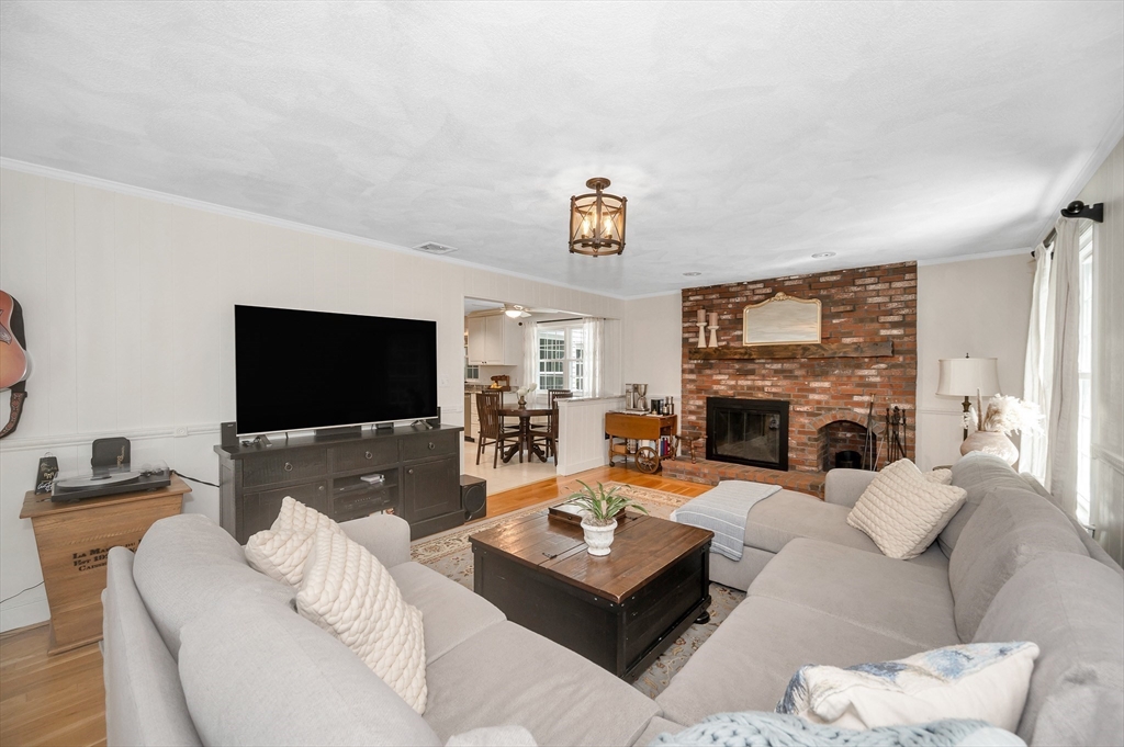 67 Reservation Road Andover, MA 01810 - Photo 18 of 40 a living room with furniture a fireplace and a flat screen tv
