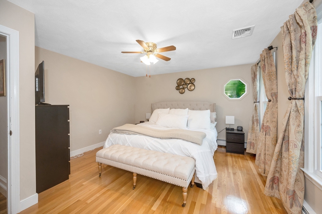 67 Reservation Road Andover, MA 01810 - Photo 20 of 40 a bedroom with a bed and a chandelier