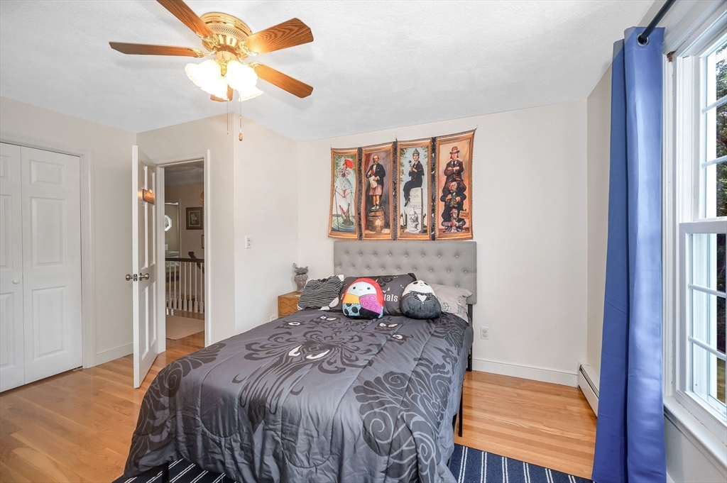 67 Reservation Road Andover, MA 01810 - Photo 27 of 40 a bedroom with a large bed and a chandelier