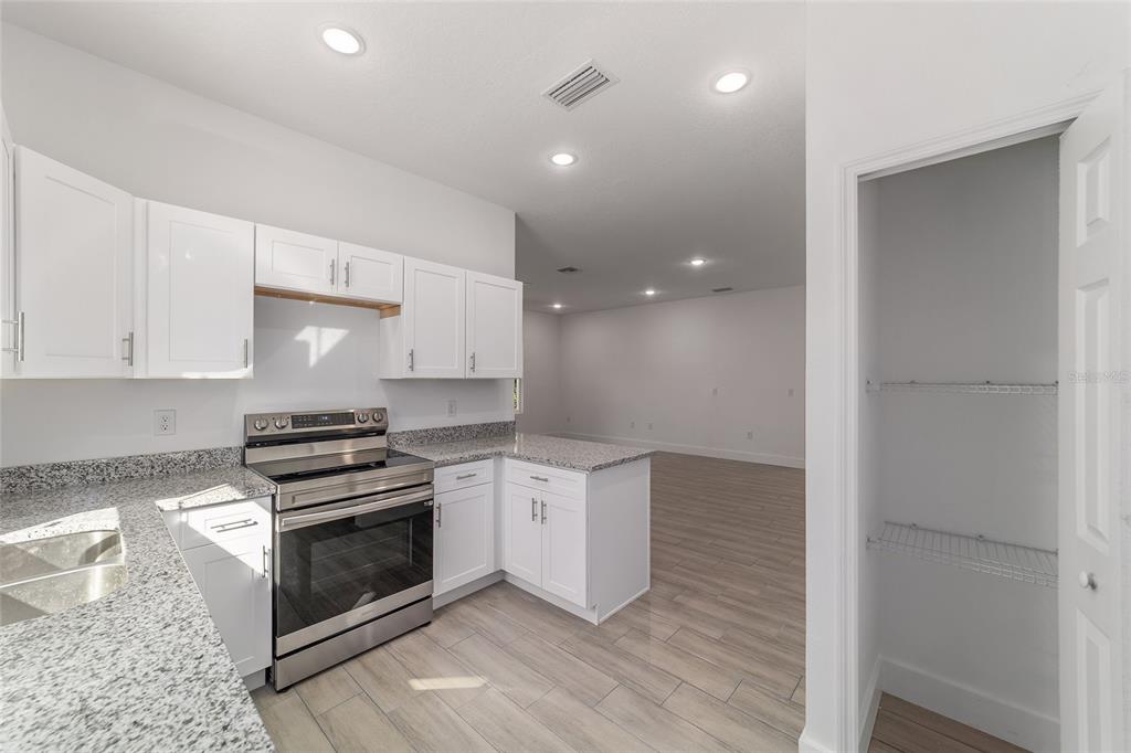 15431 Southwest 41st Street Road Ocala, FL 34481 - Photo 11 of 44 a kitchen with granite countertop a stove and a refrigerator