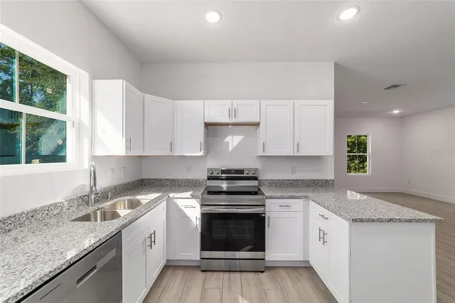 a kitchen with a stove sink and cabinets