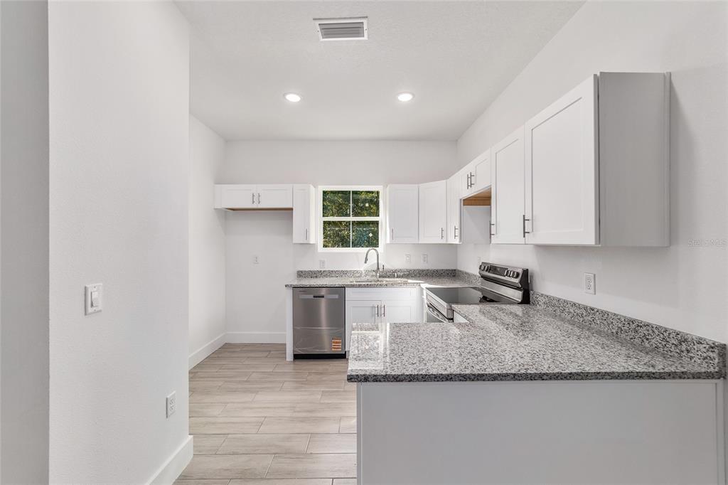 15431 Southwest 41st Street Road Ocala, FL 34481 - Photo 14 of 44 a kitchen with granite countertop a sink a stove and cabinets