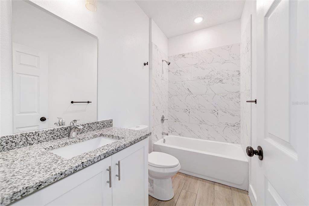 15431 Southwest 41st Street Road Ocala, FL 34481 - Photo 23 of 44 a bathroom with a granite countertop sink toilet and shower