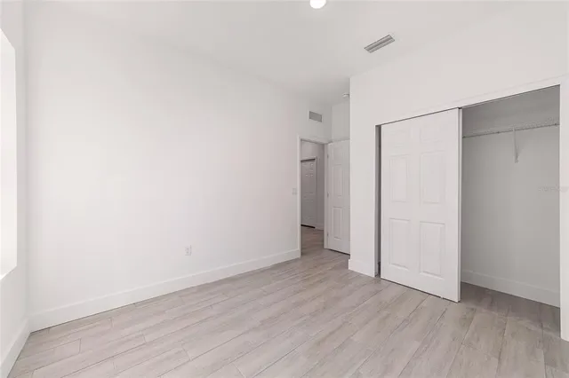 a view of an empty room with wooden floor