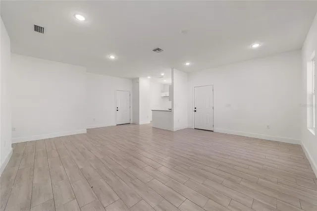 a view of an empty room with wooden floor