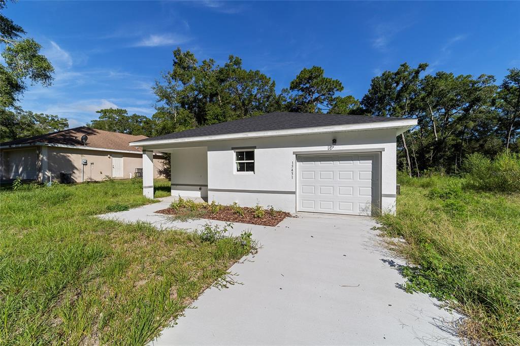 15431 Southwest 41st Street Road Ocala, FL 34481 - Photo 4 of 44 a front view of a house with a yard and garage