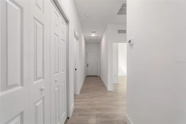 a view of a hallway with wooden floor and staircase