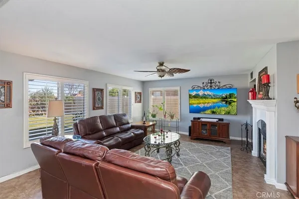a living room with furniture a ceiling fan and a window
