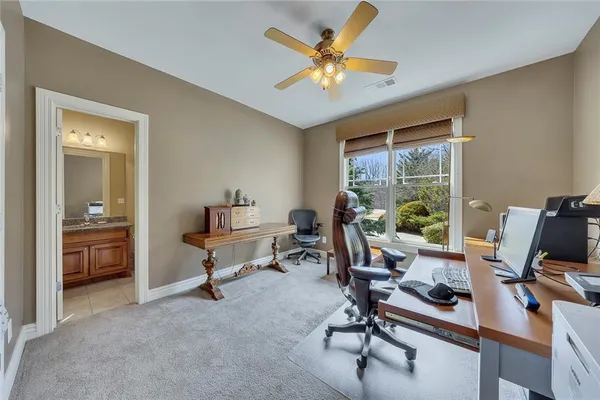 a view of a workspace with furniture and a window