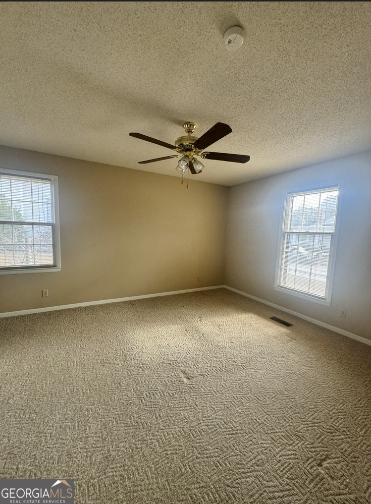 301 Church Street Vienna, GA 31092 - Photo 11 of 12 an empty room with windows and fan