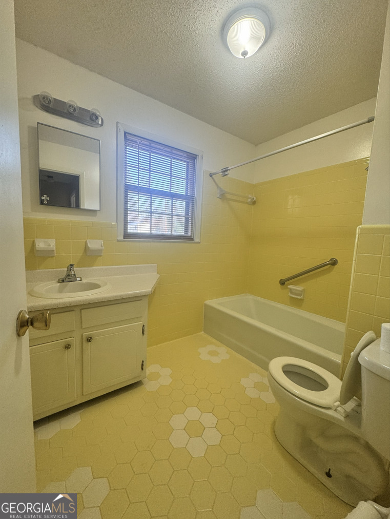 301 Church Street Vienna, GA 31092 - Photo 5 of 12 a bathroom with a granite countertop sink toilet and shower