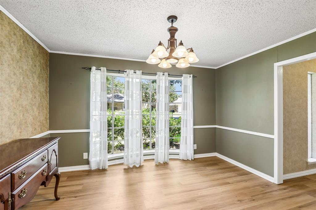 1600 South Timber Court Benbrook, TX 76126 - Photo 7 of 30 Spacious room featuring wood-finish flooring, a multi-paned window, and a decorative chandelier
