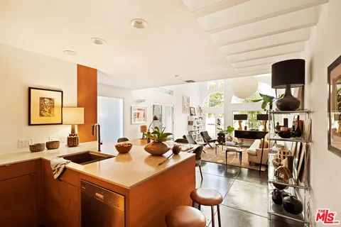 a room with lots of white furniture and flat screen tv