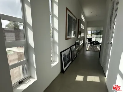 a view of a hallway with wooden floor and livingroom