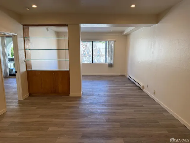 an empty room with wooden floor and cabinet