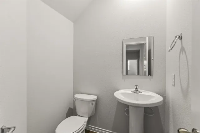 a bathroom with a sink a toilet and mirror