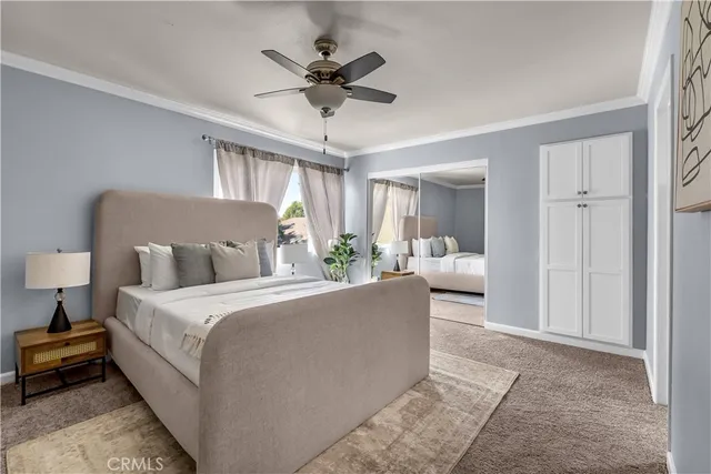 a living room with a bed furniture chandelier and a window