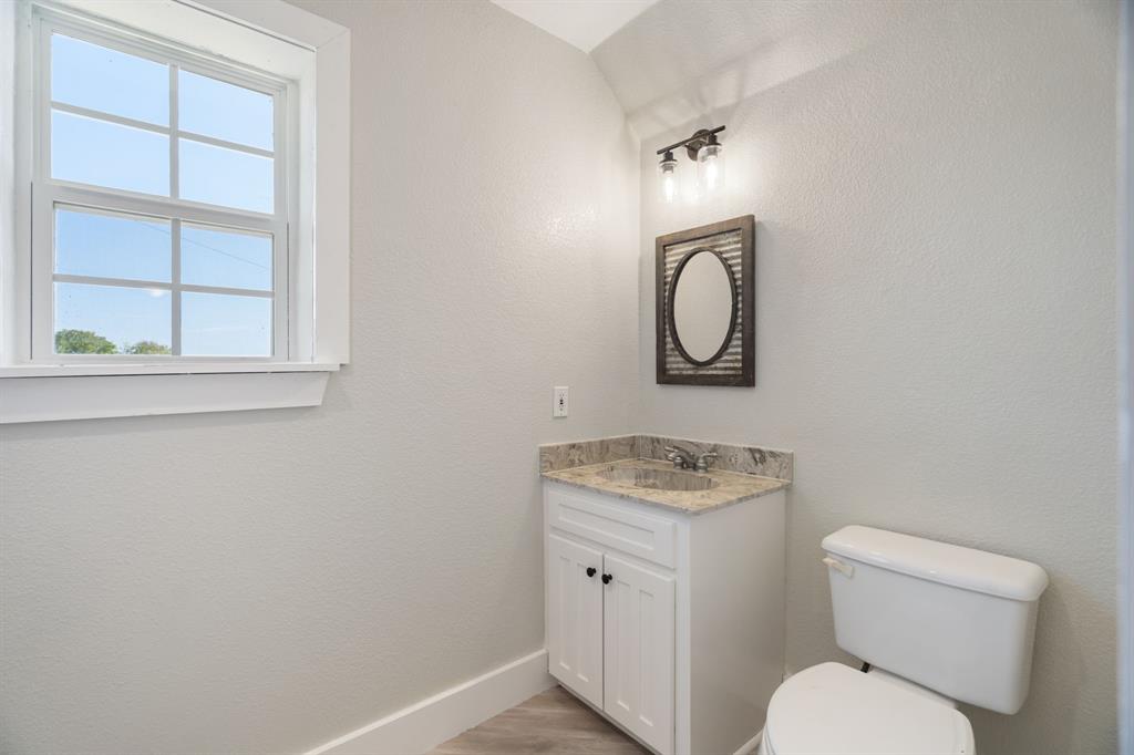 1943 Alsdorf Road Ennis, TX 75119 - Photo 27 of 38 a bathroom with a toilet sink vanity and mirror