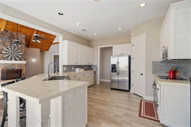 a kitchen that has a lot of cabinets a sink and appliances in it