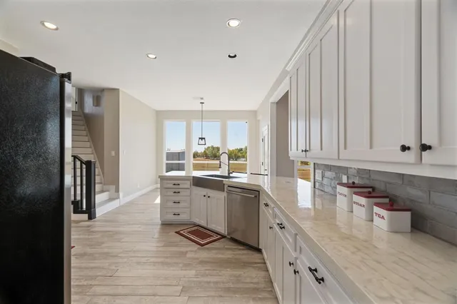 a kitchen with white cabinets and stainless steel appliances