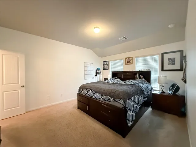a spacious bedroom with a bed and window