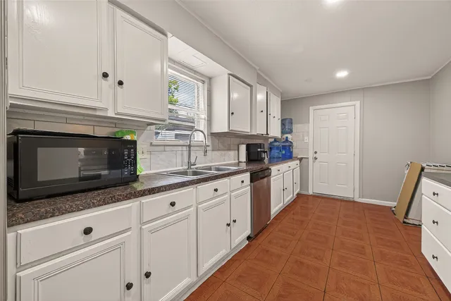 a kitchen with granite countertop white cabinets stainless steel appliances and sink