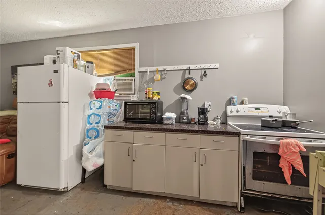 a kitchen with sink a refrigerator and cabinets