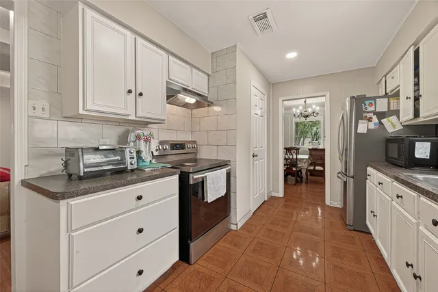 a kitchen with granite countertop white cabinets and white appliances