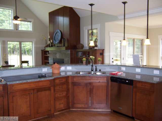 Kitchen. Kitchen opens to Greatroom and glassed in Breakfast room.  Kitchen has hardwood floors, granite countertops, glass tile backsplash, Custom Buffet and stainless steel KitchenAide appliances.