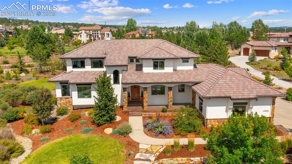 13625 Random Ridge View Colorado Springs, CO 80921 - Photo 1 of 50 Mediterranean / spanish home with stone siding, a porch, stucco siding, and a tiled roof