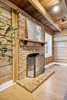 a view of a dining room and livingroom with furniture wooden floor a rug a potted plant and a chandelier