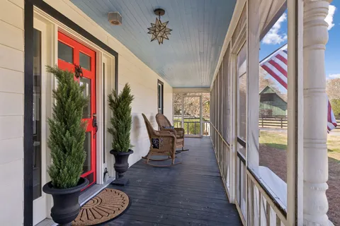 a view of a balcony with furniture and floor to ceiling window and wooden fence