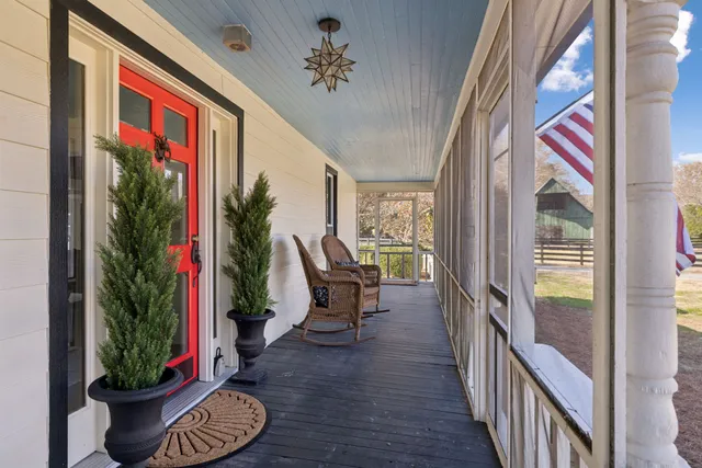 a view of a balcony with furniture and floor to ceiling window and wooden fence