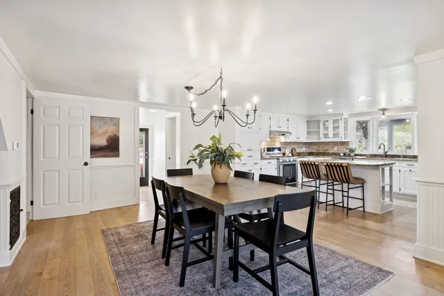 a kitchen with stainless steel appliances granite countertop a sink a stove and a granite counter tops with white cabinets
