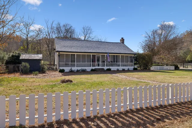 a view of empty room with wooden floor and windows