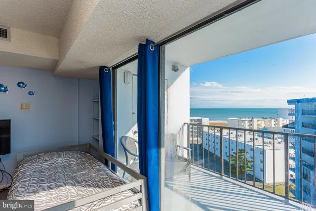 a bedroom with a bed couch and a large window