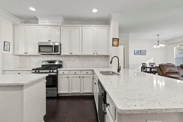 a kitchen with kitchen island granite countertop a stove and a sink