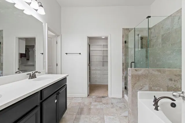 a bathroom with a tub sink and mirror