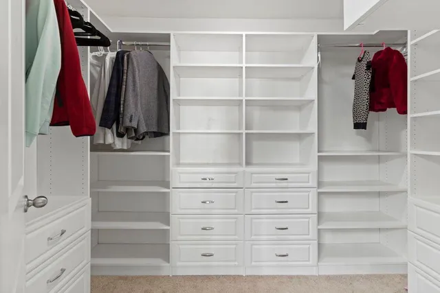 a view of walk in closet with clothes and shoes