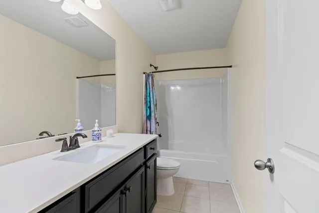 a bathroom with a sink toilet double vanity and shower