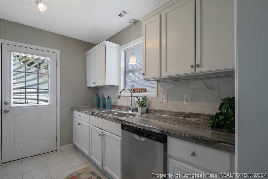 130 Rye Lane Raeford, NC 28376 - Photo 12 of 38 a kitchen with stainless steel appliances granite countertop a sink and a white cabinets