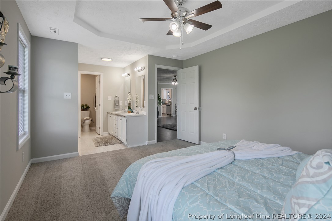 130 Rye Lane Raeford, NC 28376 - Photo 18 of 38 a bedroom with a large bed and chandelier fan