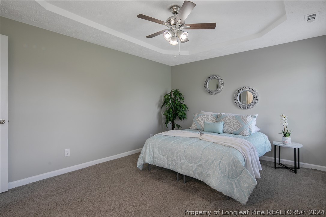 130 Rye Lane Raeford, NC 28376 - Photo 19 of 38 a bedroom with a bed and a chandelier