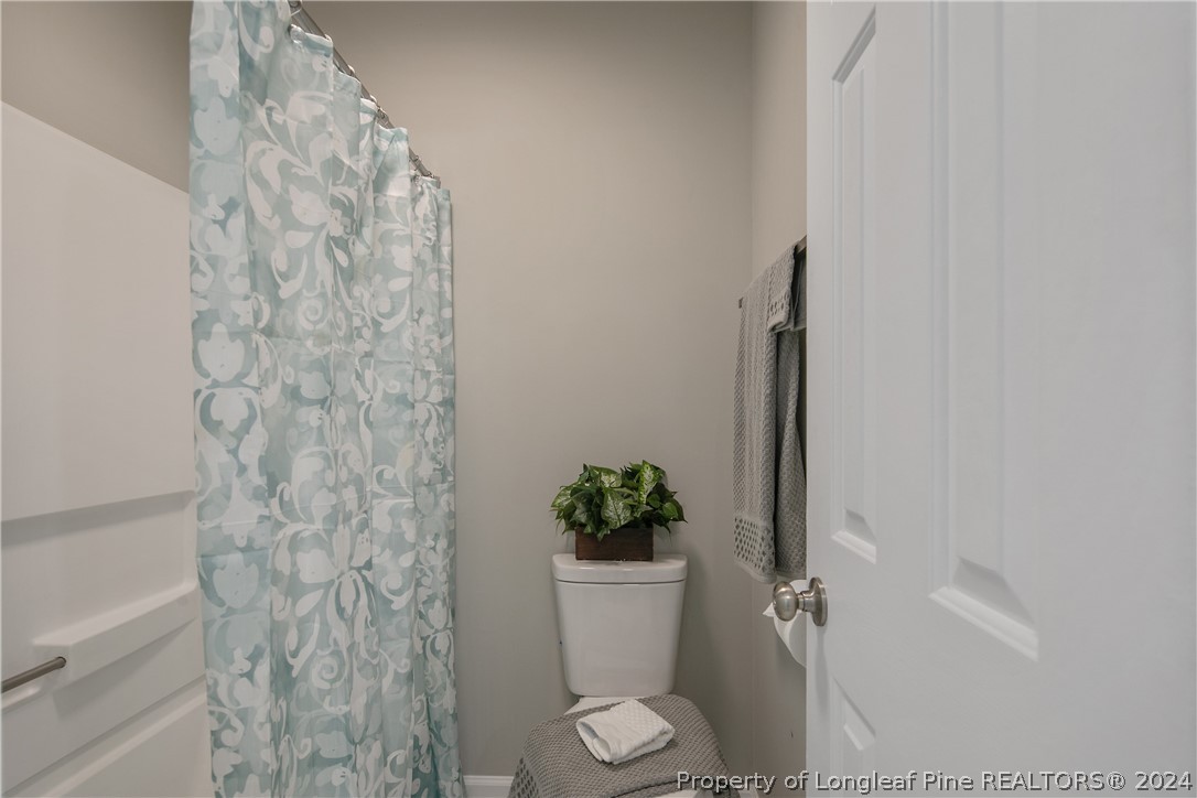 130 Rye Lane Raeford, NC 28376 - Photo 24 of 38 a white toilet sitting next to a shower curtain
