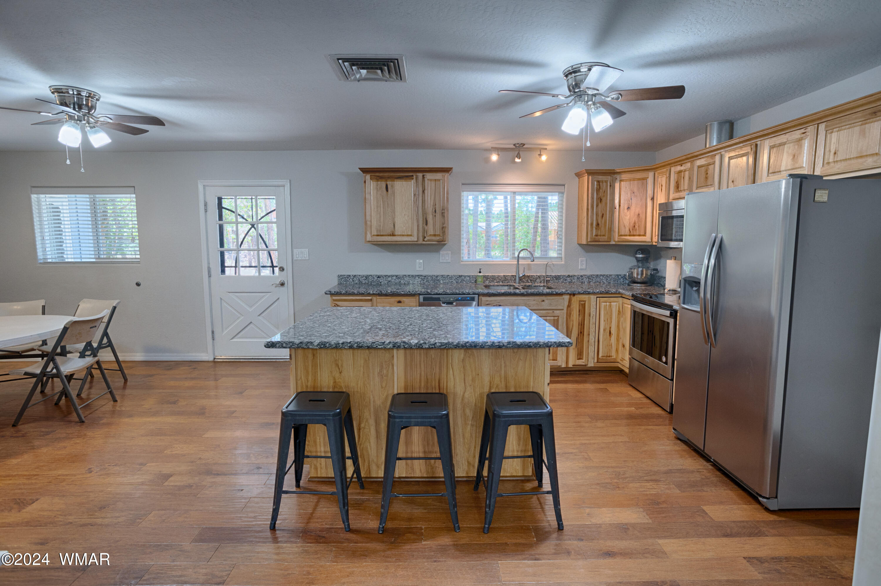 625 East Nora Place Pinetop, AZ 85935 - Photo 20 of 35 a kitchen with kitchen island a dining table chairs stainless steel appliances and cabinets