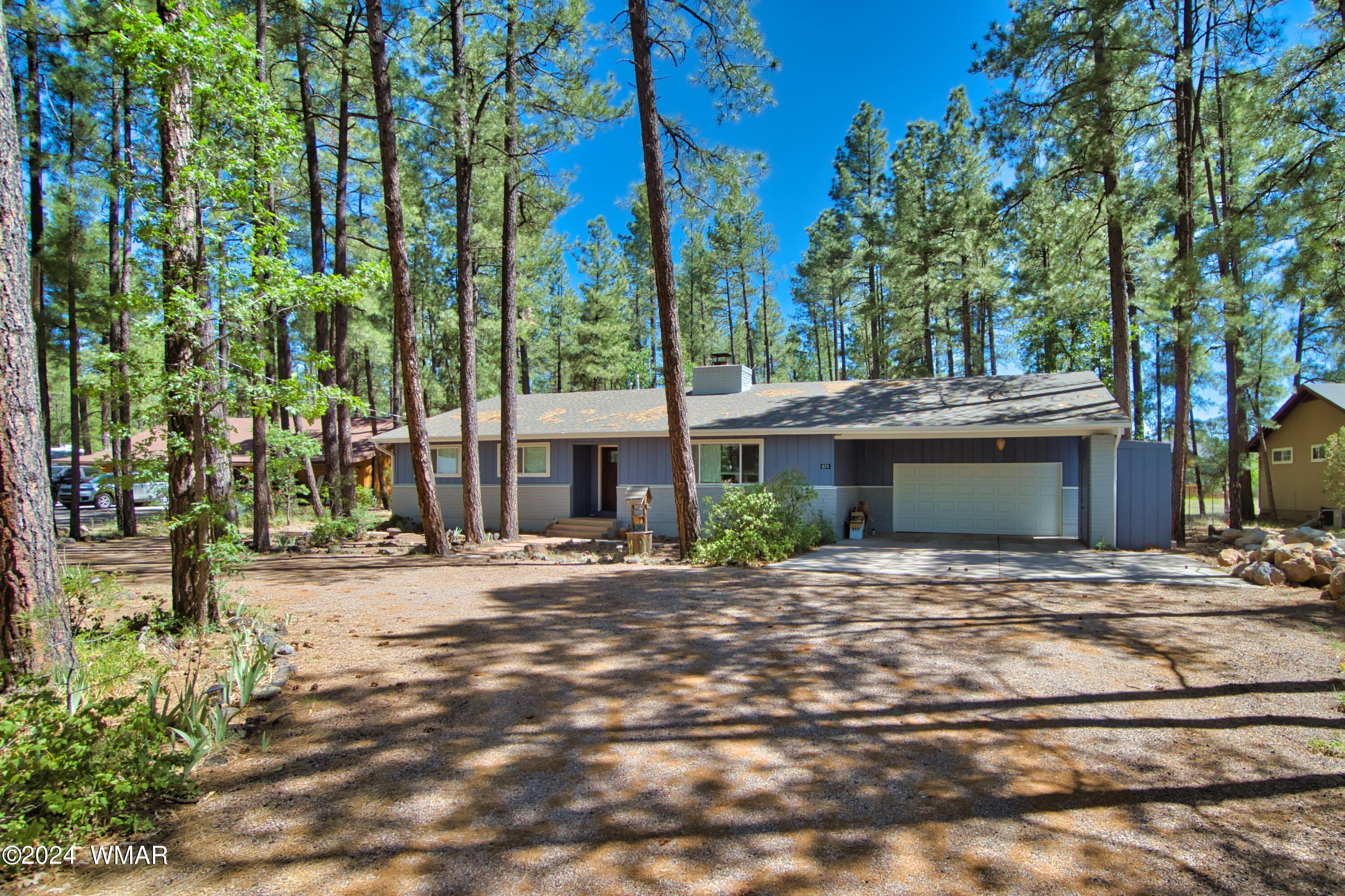 625 East Nora Place Pinetop, AZ 85935 - Photo 9 of 35 a front view of a house with a yard and tree s