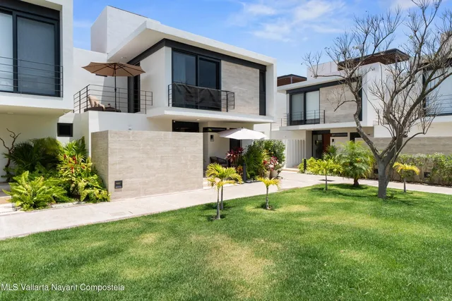 a view of an house with backyard and a tree